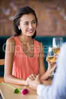 Couple holding hands while having glass of wine