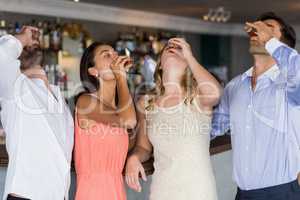 Group of friends having tequila shot