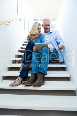 Woman with man holding digital tablet