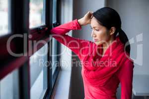 Thoughtful young woman by window