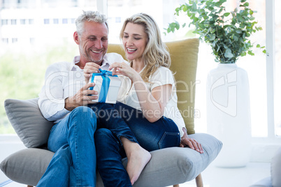 Smiling mature couple with gift box