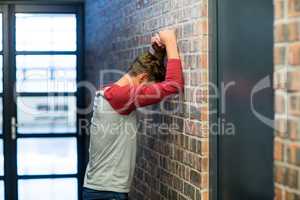 Side view of stressed man leaning on wall