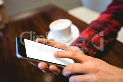 Person using mobile phone at table in restaurant