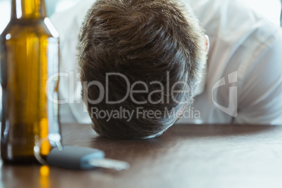 Depressed man with head down on a bar counter