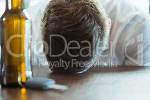 Depressed man with head down on a bar counter