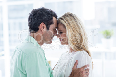 Mid adult couple embracing at home