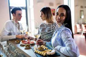 Woman having food with friends at bar counter