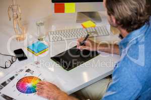 Businessman using graphics tablet at desk