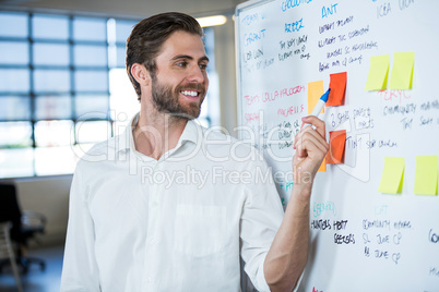 Businessman smiling while pointing on sticky note