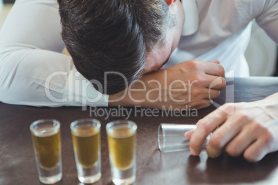 Drunken man sleeping on a bar counter