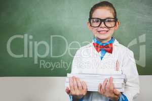 Portrait of smiling girl standing with a stack of books in class