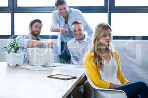Colleagues laughing on businesswoman in office