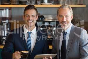 Business colleague using digital tablet in cafÃ©