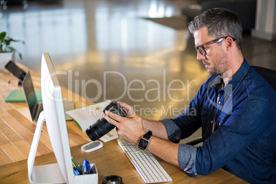 Focused man holding camera in office