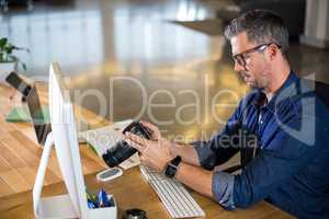 Focused man holding camera in office