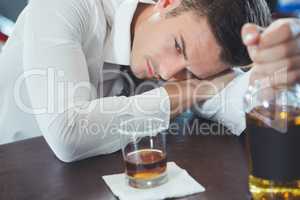 Drunken man lying on a bar counter