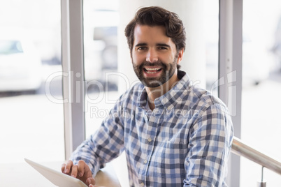 Portrait of smiling man using digital tablet