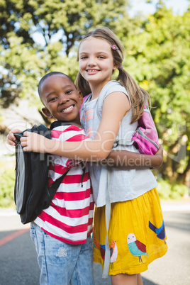 Schoolkids embracing each other in campus