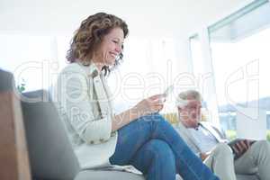 Joyful woman by man using digital tablet