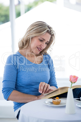 Smiling mature woman reading book