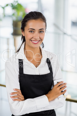 Portrait of smiling waitress standing with arms crossed Portrait of smiling waitress standing with arms crossed