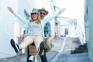 Happy couple enjoying while riding bicycle