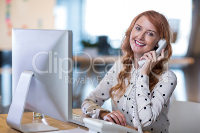Creative businesswoman talking on telephone