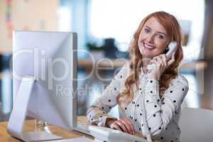 Creative businesswoman talking on telephone