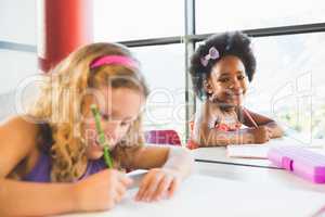 Portrait of girl doing homework in classroom