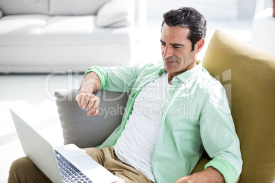 Man using laptop while siting on couch