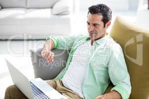 Man using laptop while siting on couch