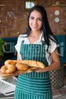 Waitress holding wooden tray with bread