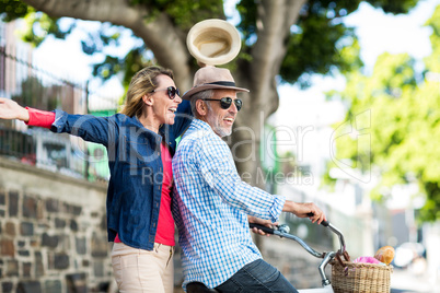 Mature couple enjoying while riding bicycle