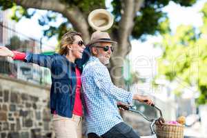 Mature couple enjoying while riding bicycle