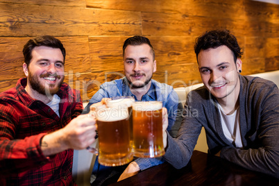 Male friends toasting beer at restaurant