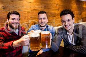Male friends toasting beer at restaurant