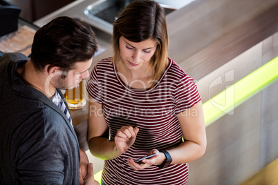 Couple looking at cellphone while standing by