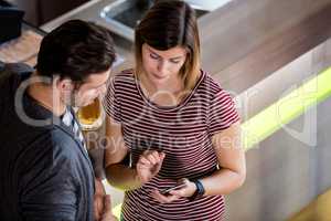 Couple looking at cellphone while standing by