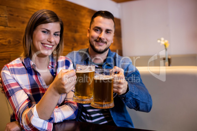 Cheerful couple toasting beer mug