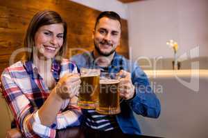 Cheerful couple toasting beer mug