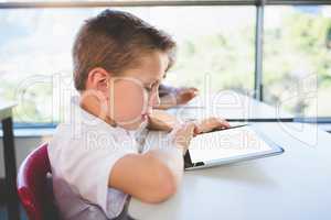 Schoolkid using digital tablet in classroom