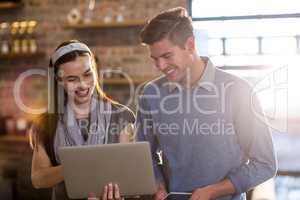 Young colleagues using laptop in office