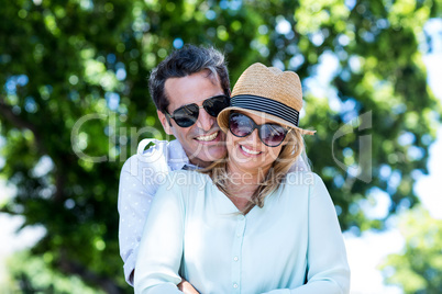 Couple embracing against trees