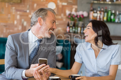 Business colleagues interacting with each other while having tea