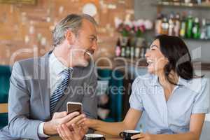 Business colleagues interacting with each other while having tea