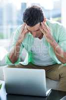 Stressed man with laptop at home