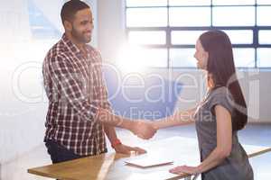 Colleagues shaking hands in office