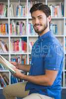School teacher reading book in library