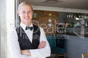 Waiter with arms crossed in restaurant