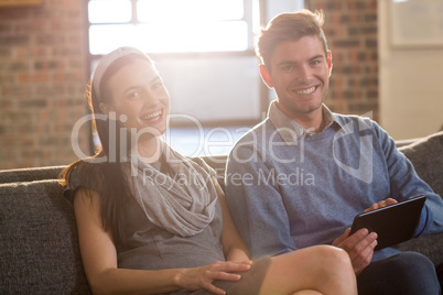 Young colleagues sitting on sofa in office